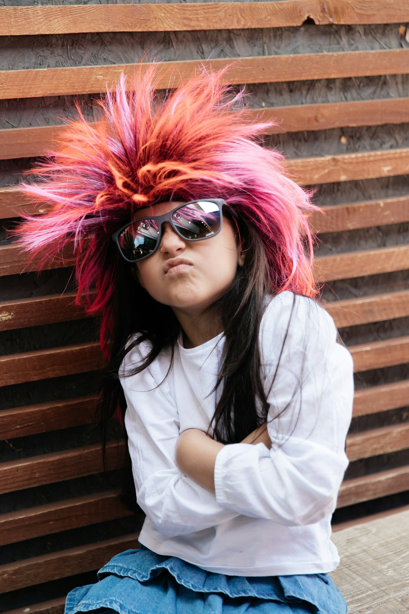 Cheerful little girl in a pink wig